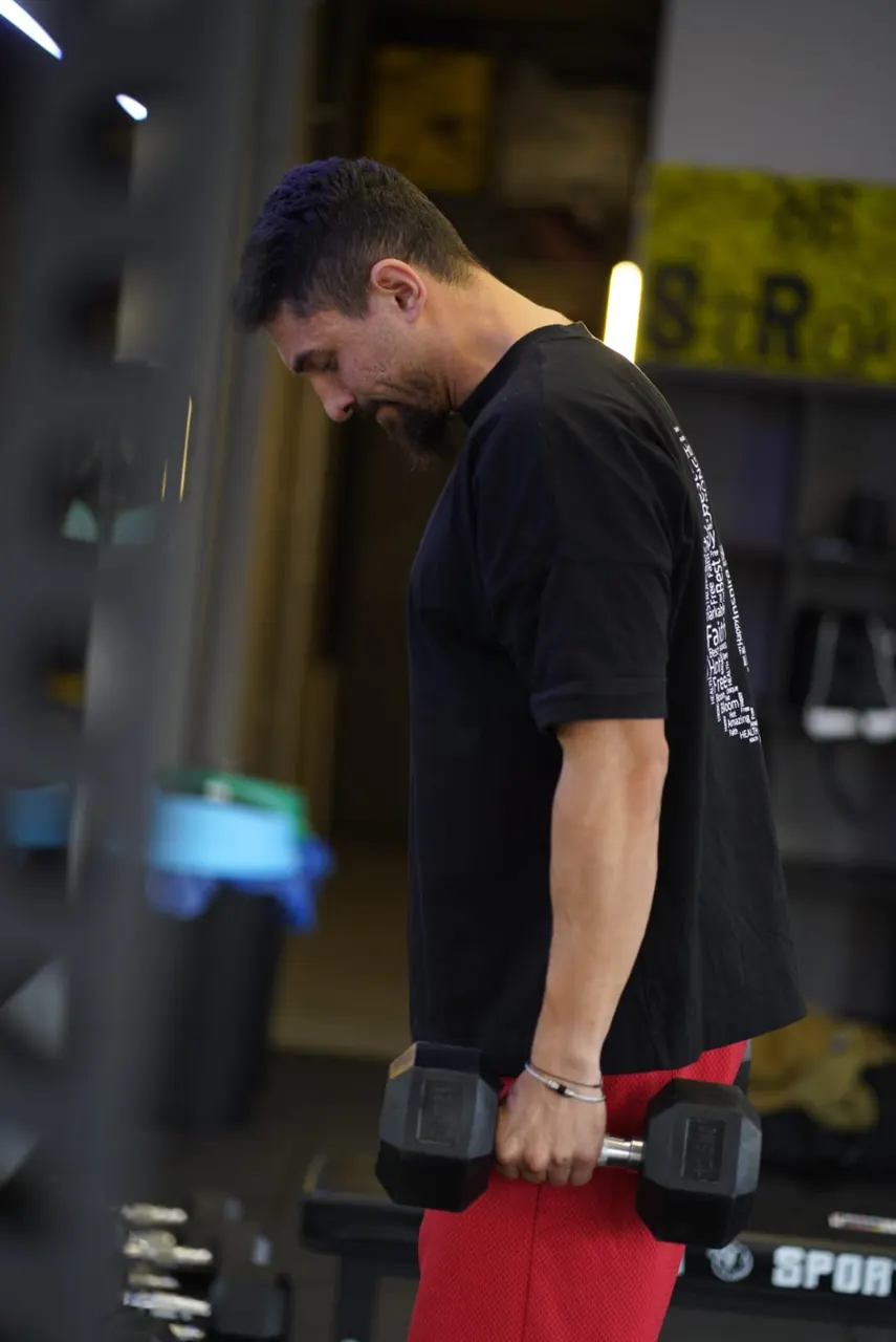Bogdan lucrând cu gantere în Be Strong Studio